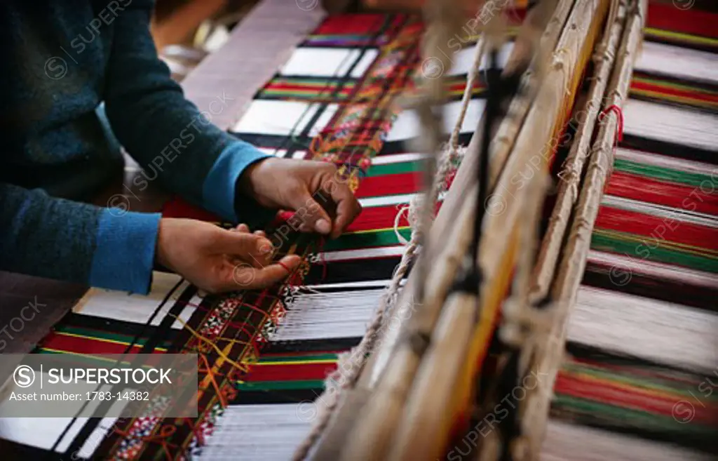A Mizo woman operating a mechanical handloom producing traditional Mizo fabric, Thenzawl , Mizoram , North East states , India