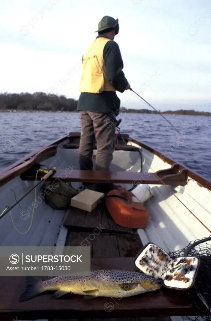 Man fishing for wild brown trout in a row boat, Lough Carra,  County Mayo