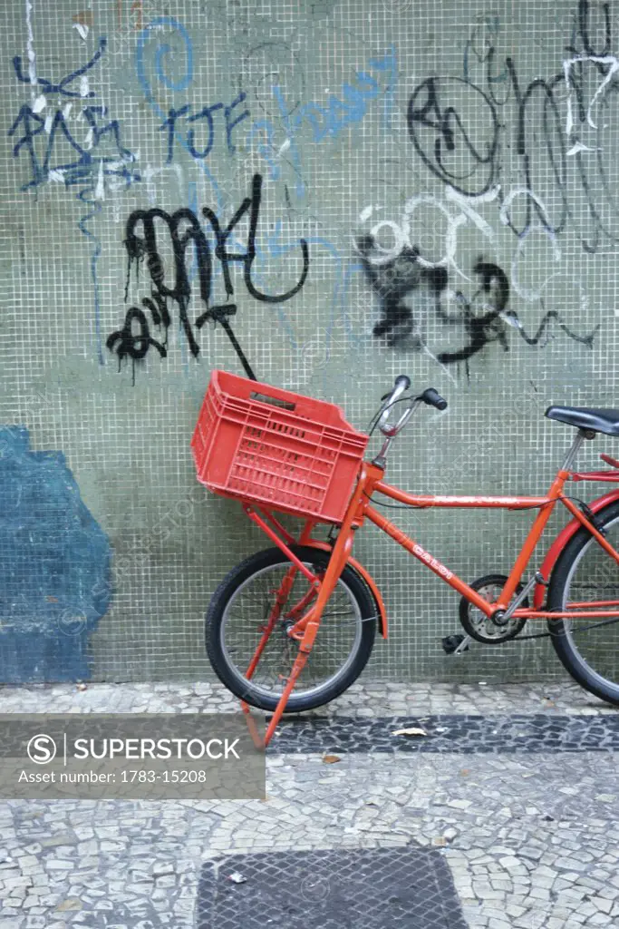 Bicycle leaning against wall with graffiti, Naples, Italy
