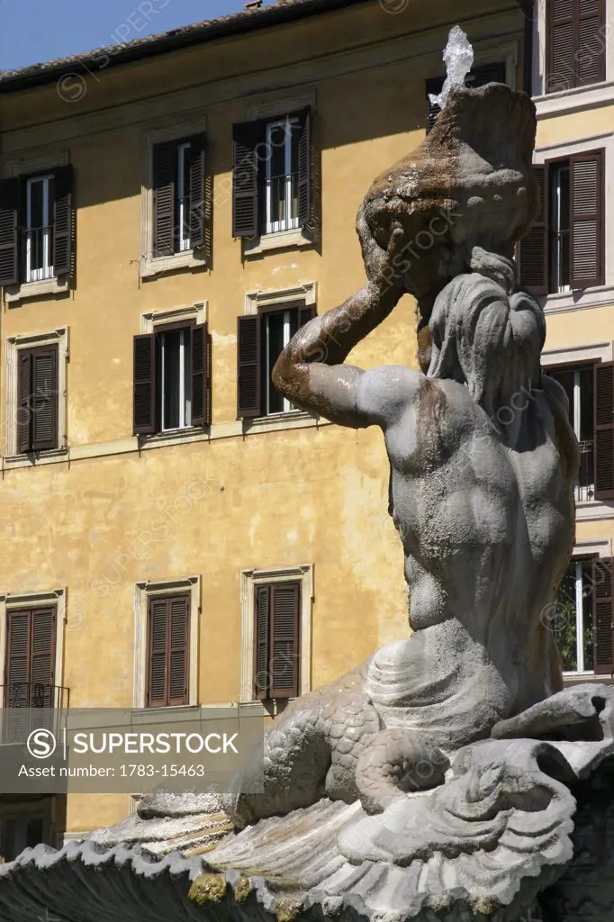 The Tritone Fountain and yellow building, Piazza Barberini, Rome, Italy