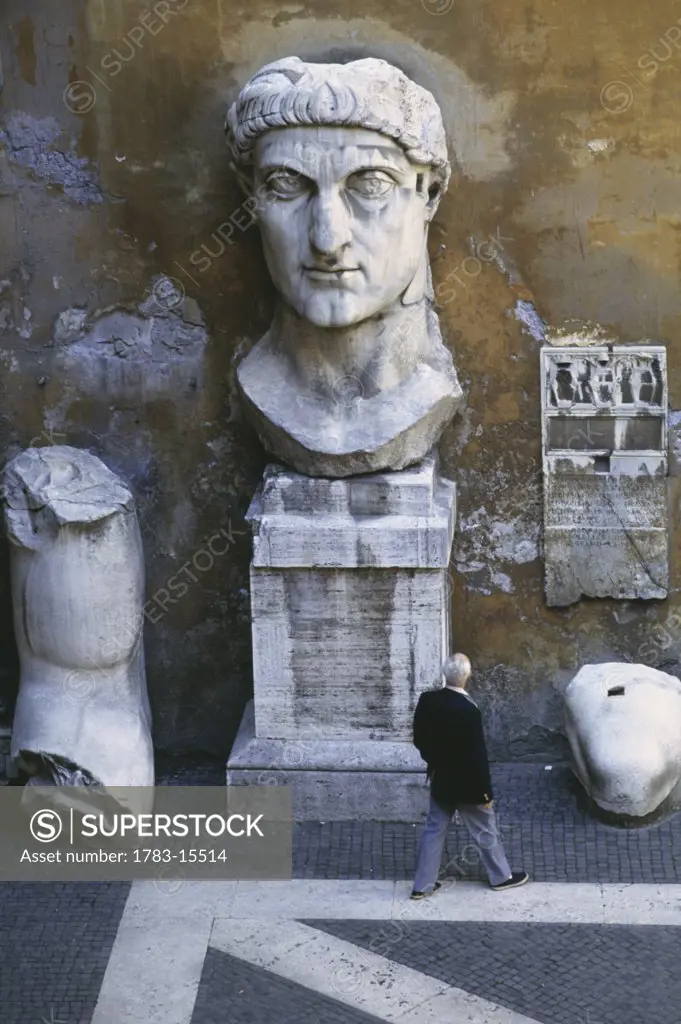 Man walking by statues at Courtyard of Palazzo dei Conservatori, Rome, Italy