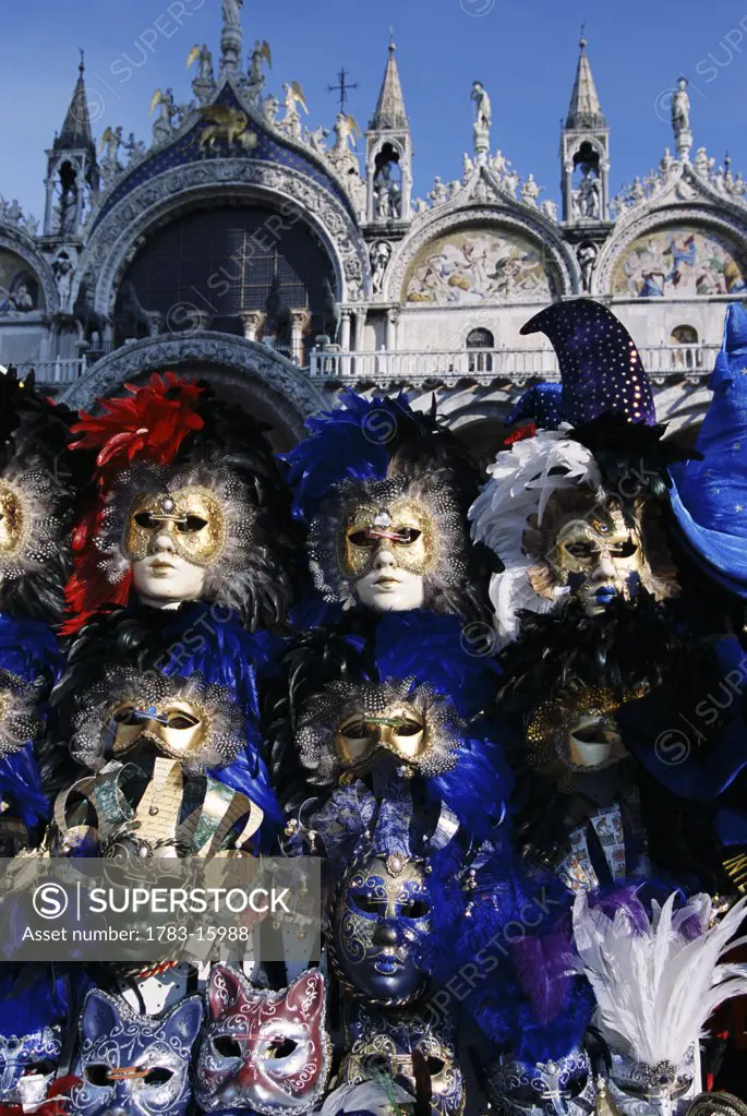 Carnival masks at a stall, St Mark's Square with Basilica in background, Venice, Italy
