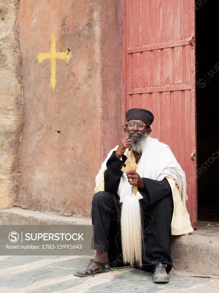 Ethiopian Orthodox priest with cross, Wukro Chirkos rock cut church; Wukro, Tigray region, Ethiopia