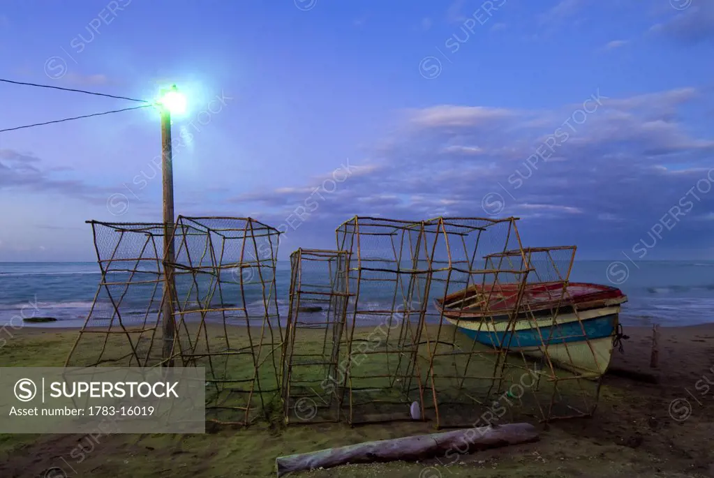 Lobster pots at the coast., Lobster pots beside fishing boat at dawn, Treasure Beach, Jamaica.