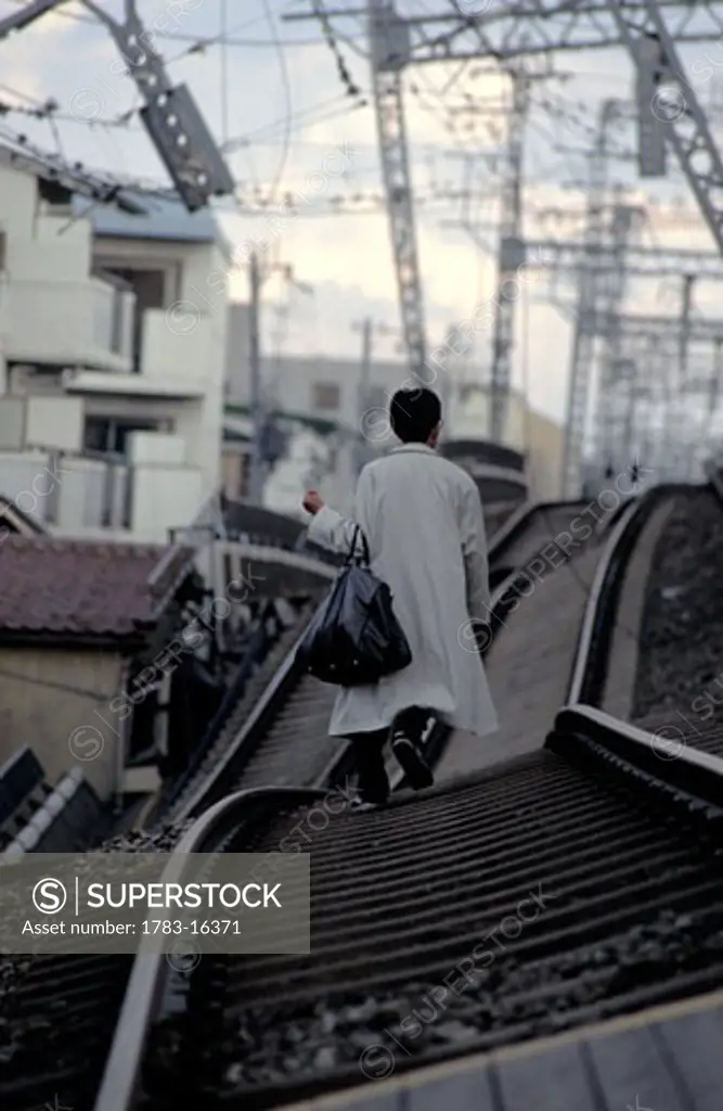Man walking on railway lines after earthquake, Kobe, Japan
