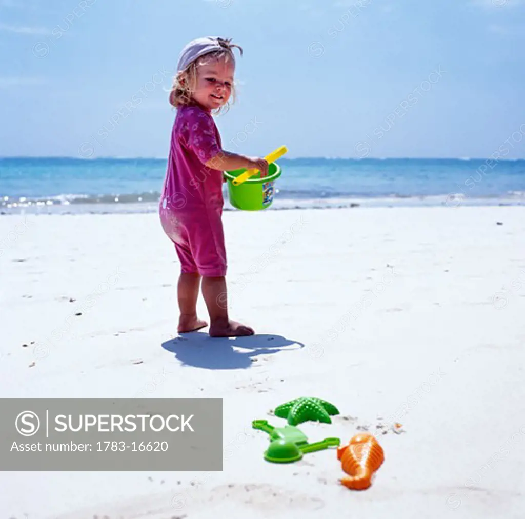 Child playing on beach with bucket and spade, Diani Beach, Mombasa Coast, Indian Ocean, Kenya