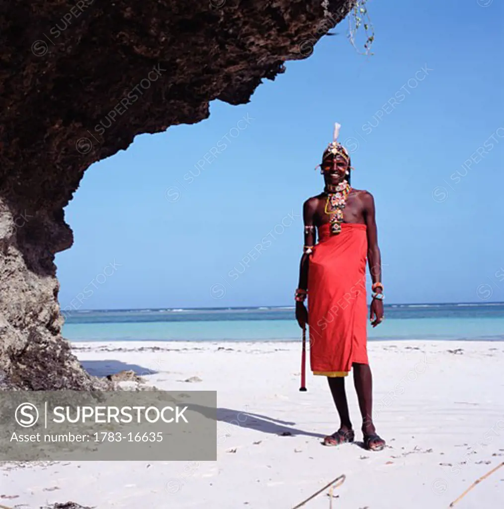 Smiling Samburu man standing on beach, Diani Beach, Mombasa Coast, Kenya