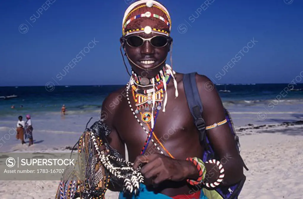 Maasai/ Mara tribesman selling beads on the beach, Diani Beach, Mombassa Coast, Kenya  .