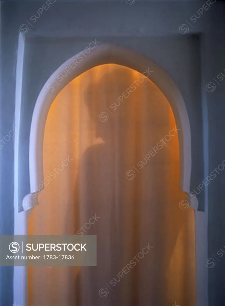 Shadow of woman through arched doorway in the Riad Dar Zelije, Marrakesh, Morocco.