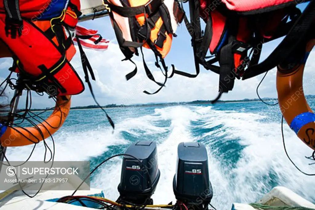 Life jackets hanging at back of speedboat, with wake on water, PulauKapas, Terengganu, Malaysia.