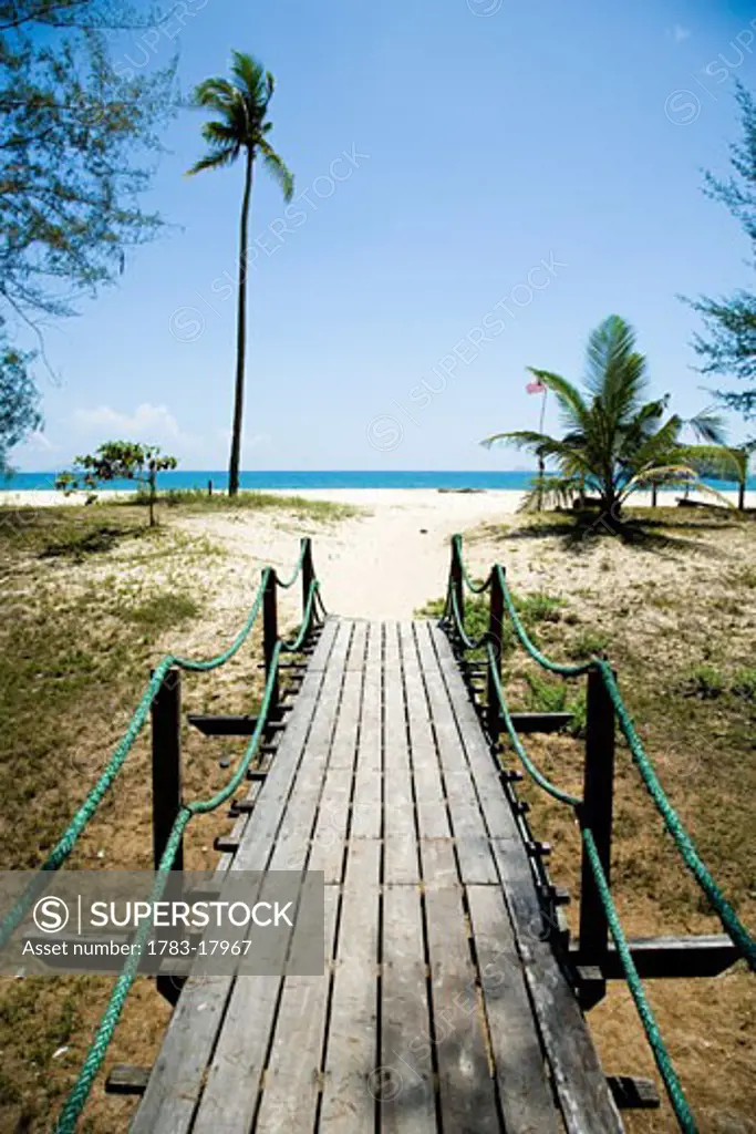 Wooden boardwalk to beach on South China Sea, Terengganu, Malaysia.