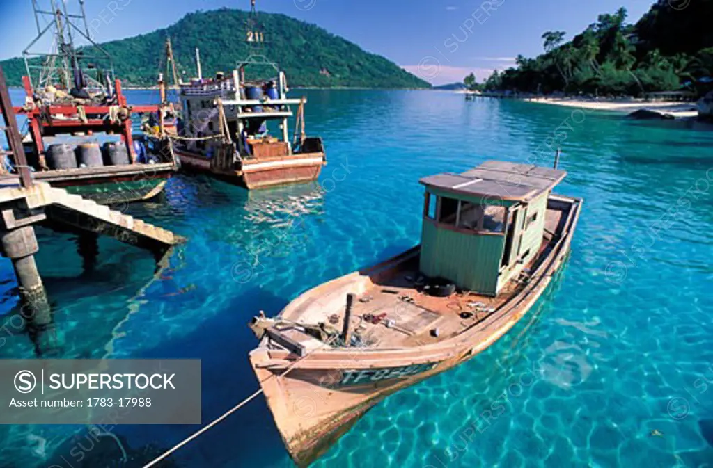 Wooden fishing boats moored in harbor with clear blue water, Pulau Perhentian, Kuala Terengganu, Malaysia