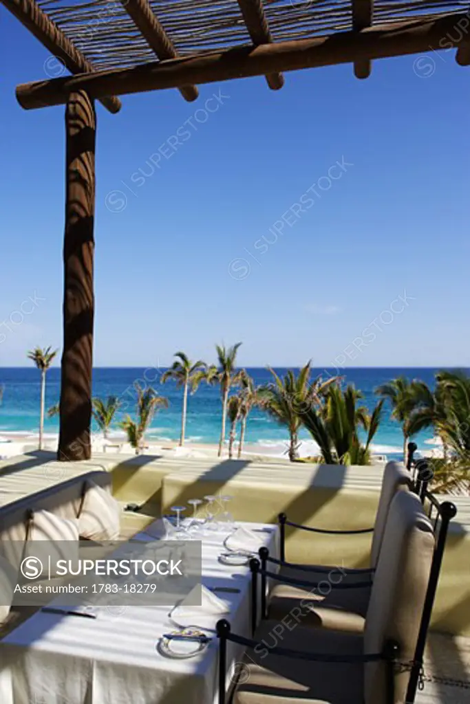 Dining tables by beach, Los Cabos, Mexico.