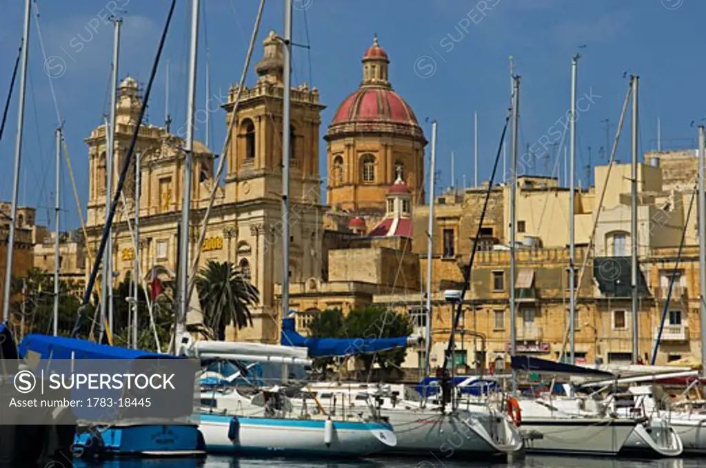 St Lawrence Church behind sailboats moored at marina, Vittoriosa, Malta.