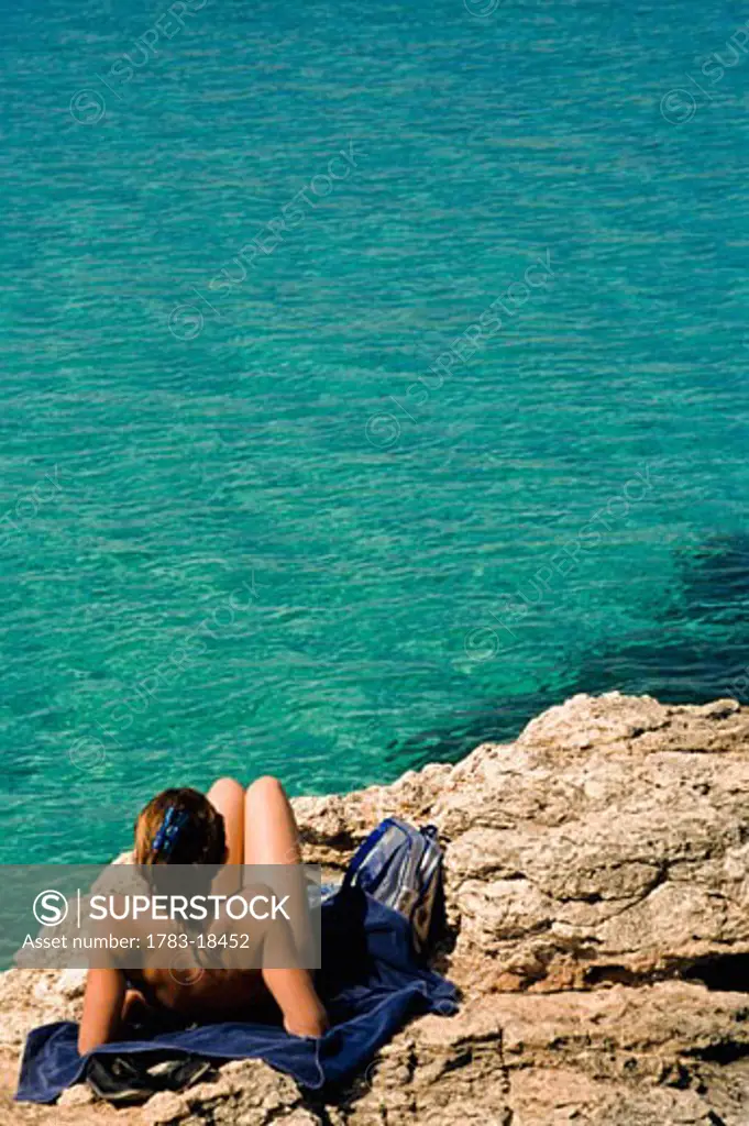 Woman sunbathing at Blue Lagoon, Comino, Malta
