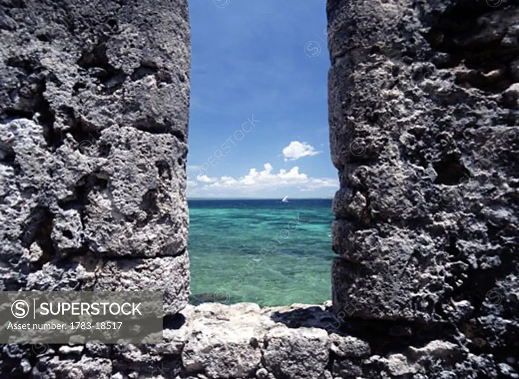 Looking through slit in the walls of the Fort of Sao Sebastiao to dhow sailing past, Ilha de Mocambique, Mozambique