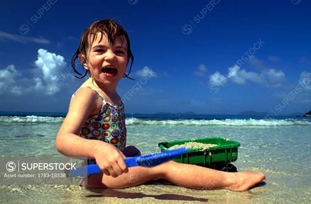 Girl (4-5) playing on beach, Mustique, St Vincent and the Grenadines.