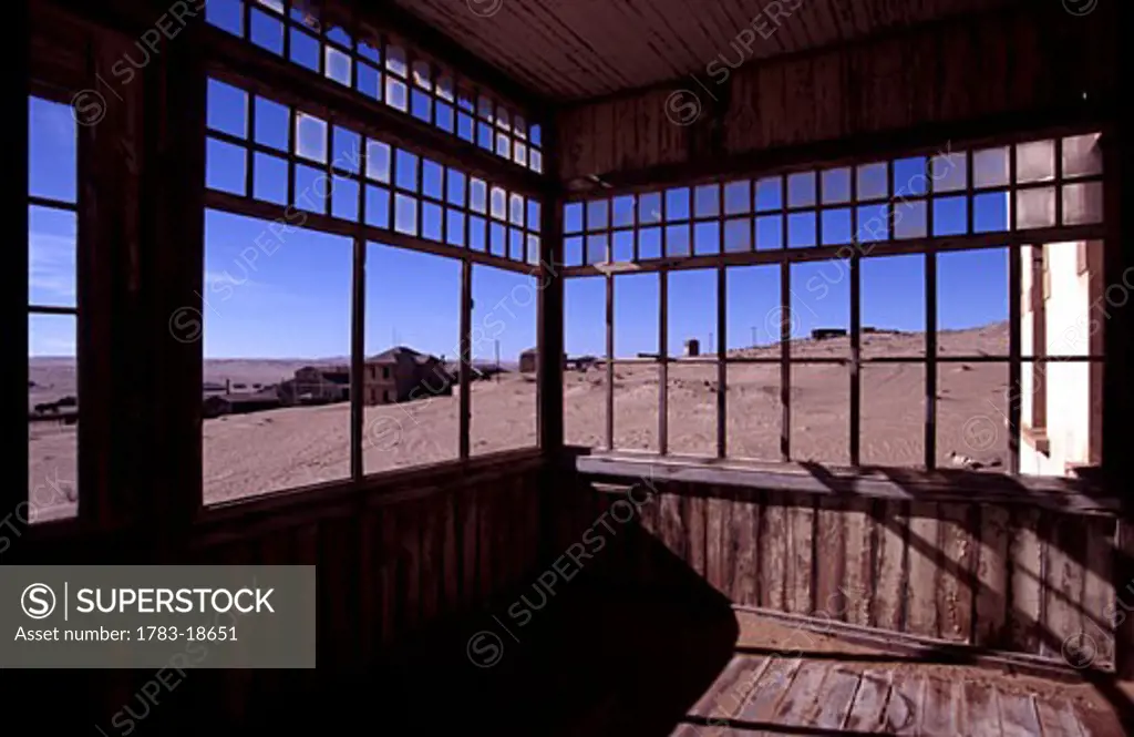 View through windows of disused building in desert ghost town, Kolmanskop, Namibia