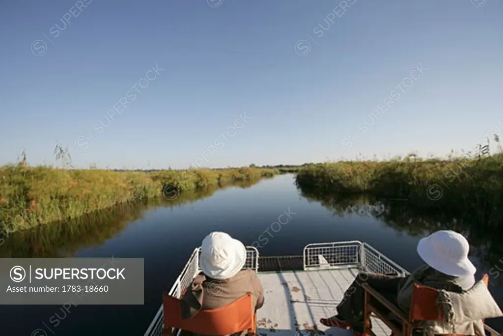 Two tourists taking a boat trip on Kwando River, Caprivi Strip, Namibia
