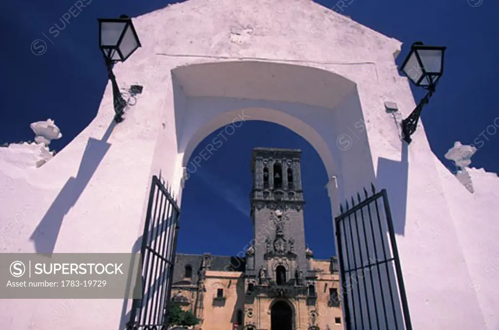 View of clock tower through whitewashed gate, Arcos de la Frontera, Andalucia, Spain
