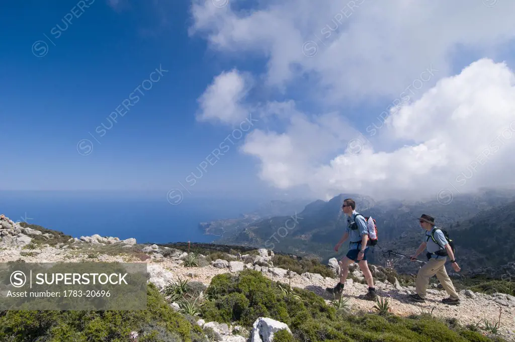 Two hikers on track towards Teix peak, side view, Majorca, Ballearic Islands, Spain, track built by Archduke Ludwig Salvador.