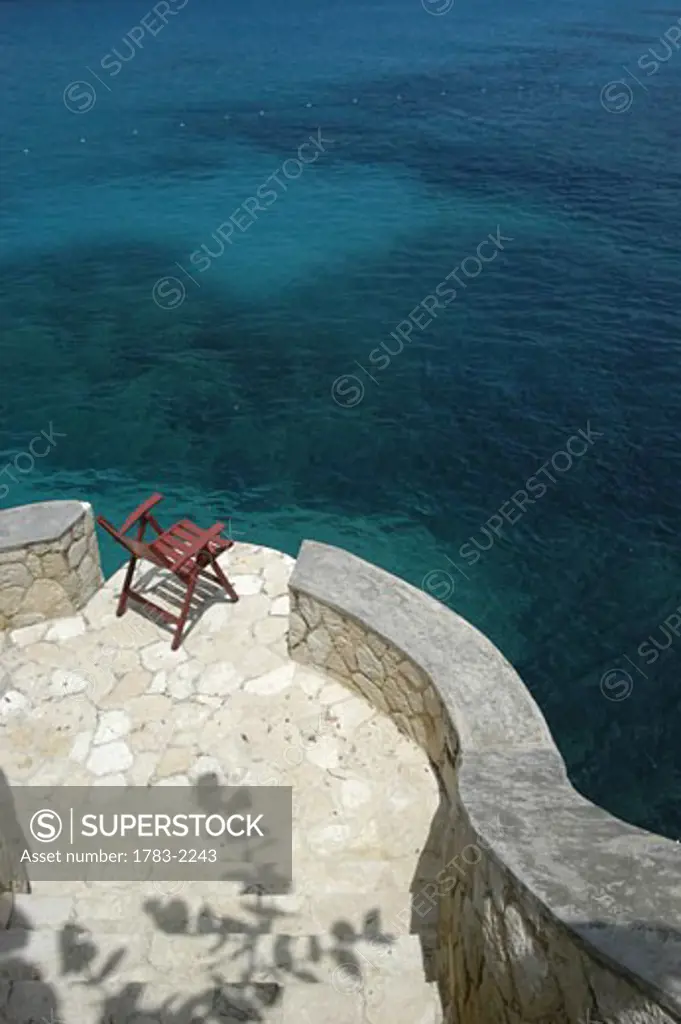Looking down to deck chairs beside the sea, The Caves, Negril, Jamaica. 