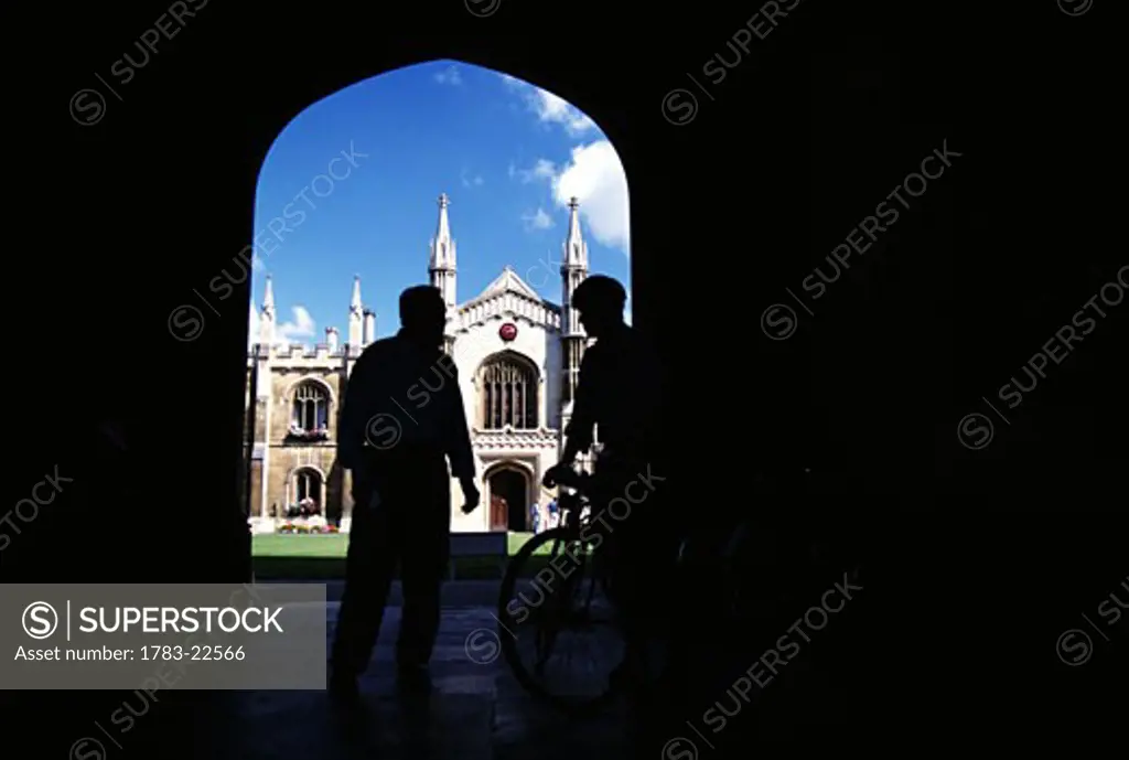 Students standing before entrance to Corpus Christi College, Cambridge, England