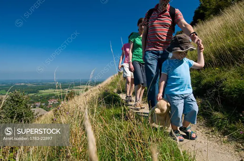 Group of adults with boy, walking along path at Devil's Dyke near Brighton, East Sussex, England..