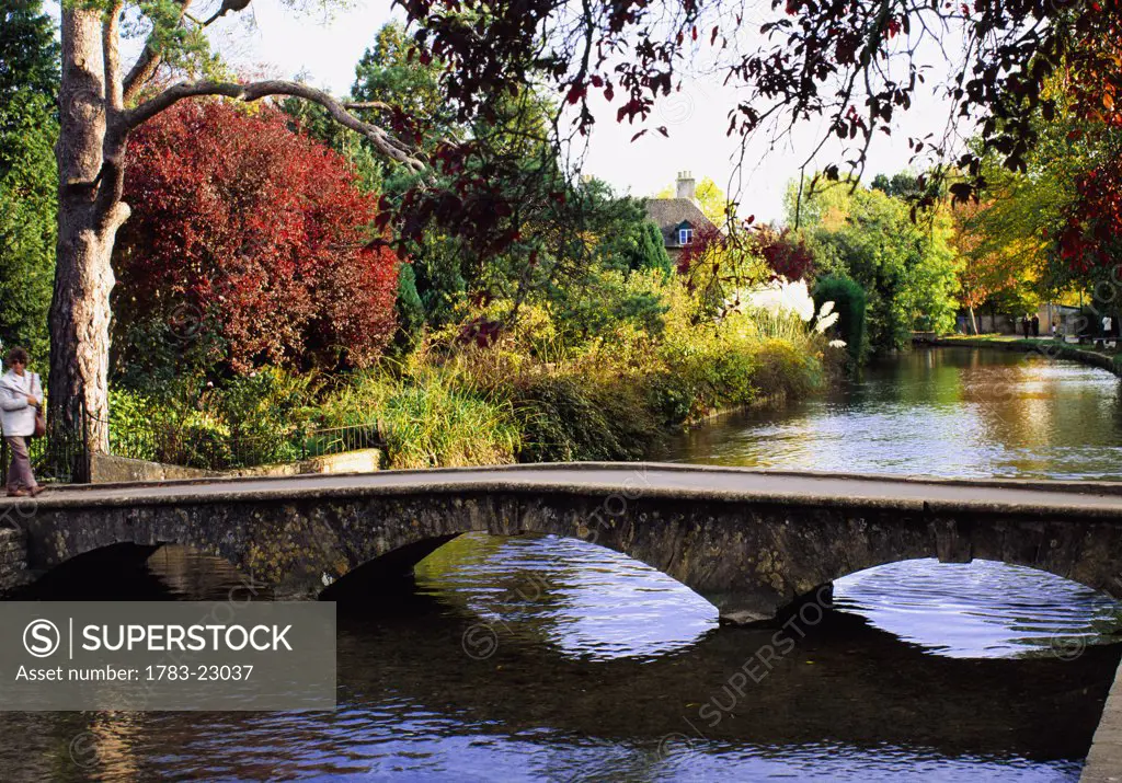 Arched stone foot bridge accros river, Bourton-on-the-Water, Cotswolds, England.