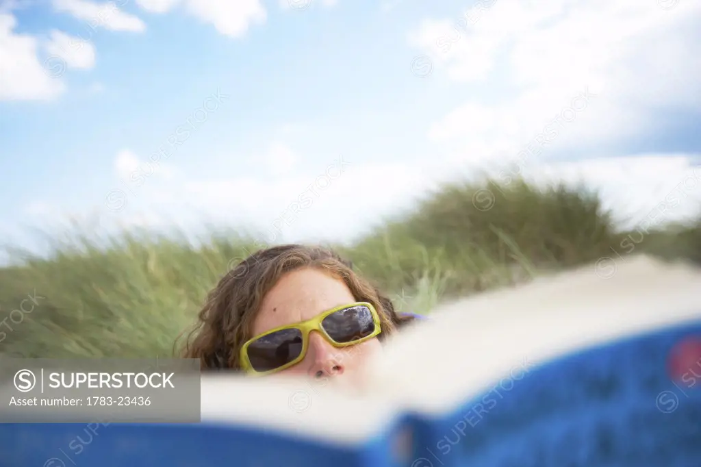 Woman reading on beach, Chichester, West Sussex, United Kingdom