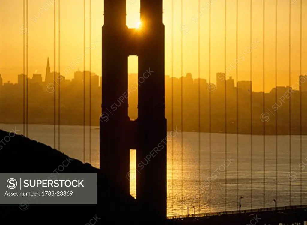 Sunrise behind the Golden Gate Bridge with skyline behind, San Francisco, California