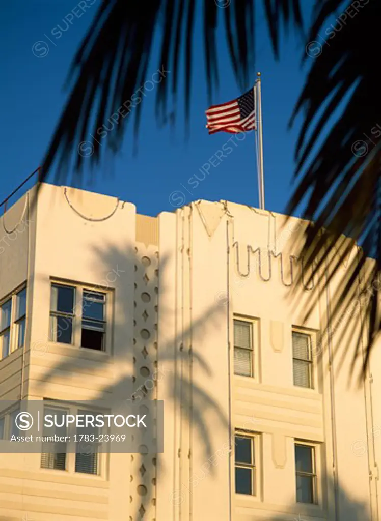  American flag on top of art deco building with palm tree shadow, South Beach, Miami, Florida, USA