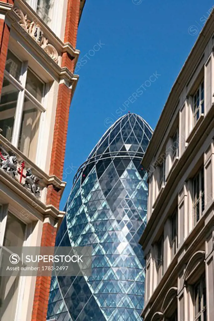 The Gerkin flanked by old buildings, The City of London, UK 