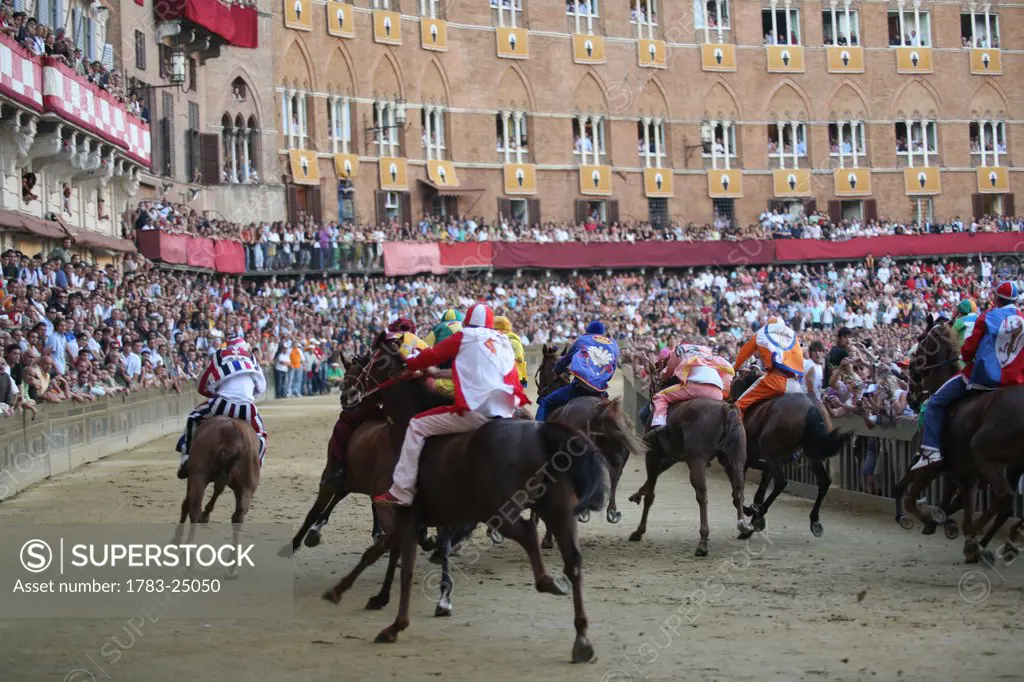 Rear view of Palio horse race around the central Campo. Palazzio Campo. Palio, Siena,Tuscany, Italy.
