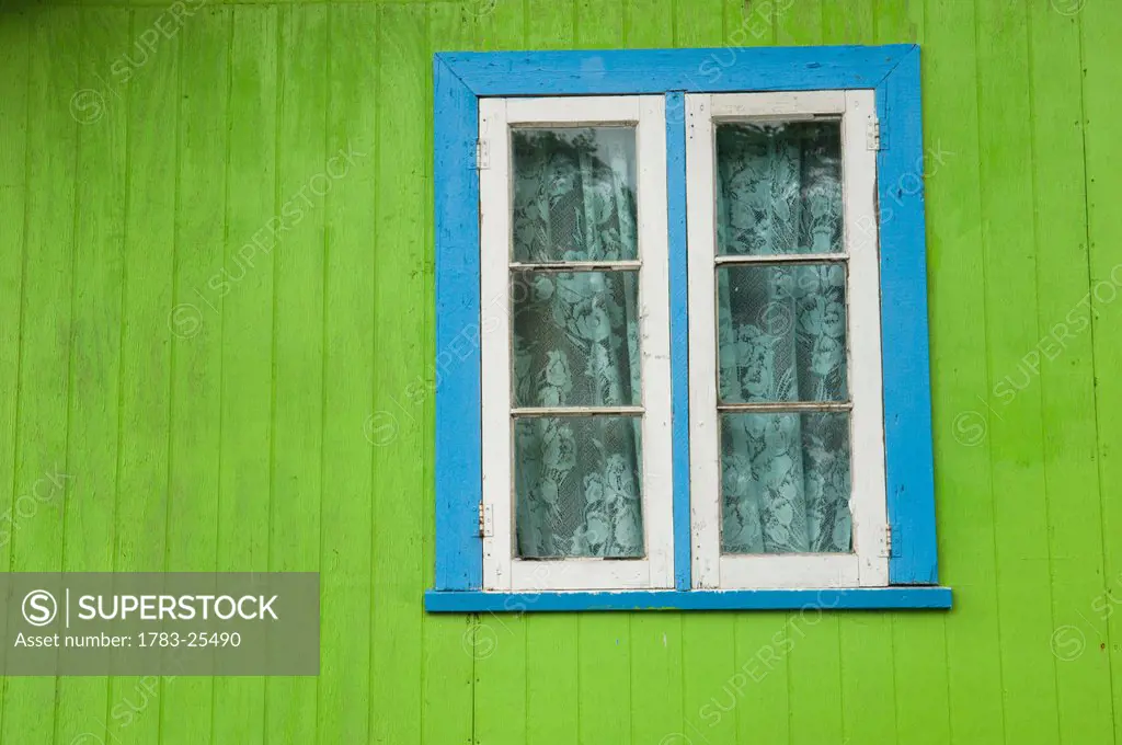 Detail of a green wooden house with blue window trim at Windward