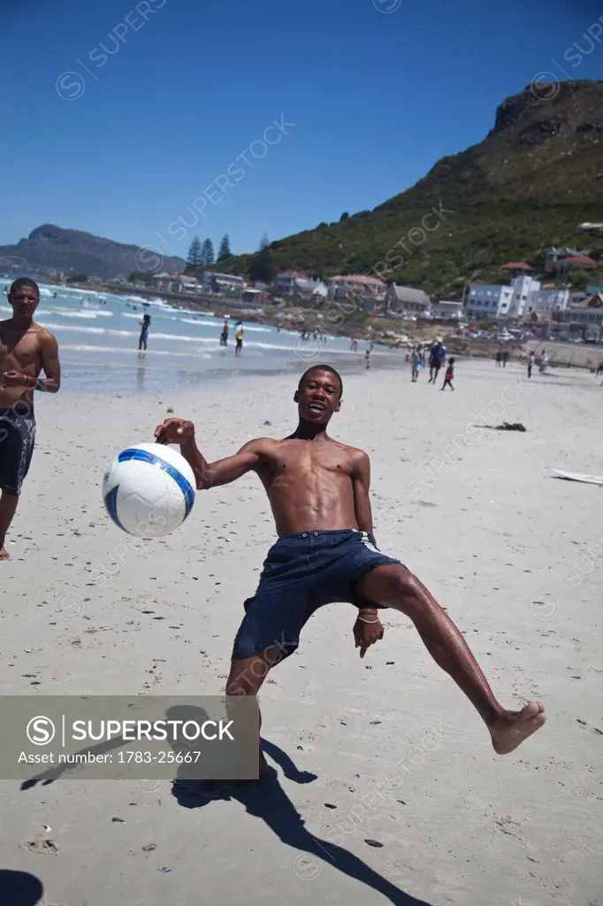 Local boys playing football on beach, Muizenberg, Cape Town, South Africa
