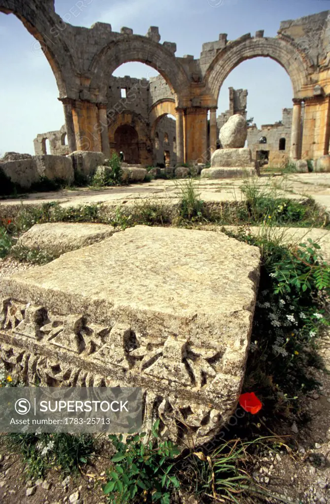 Close_up on remnants of a column with ruined arches in the background, St Simeon´s Church, Syria