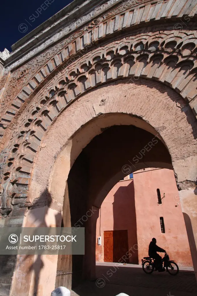 Low angle view of a scooter/ motorbike rider at Bab Agnaou, one of the nineteen gates of Marrakesh. The Bab gate Agnaou gives entrance to the royal ka...
