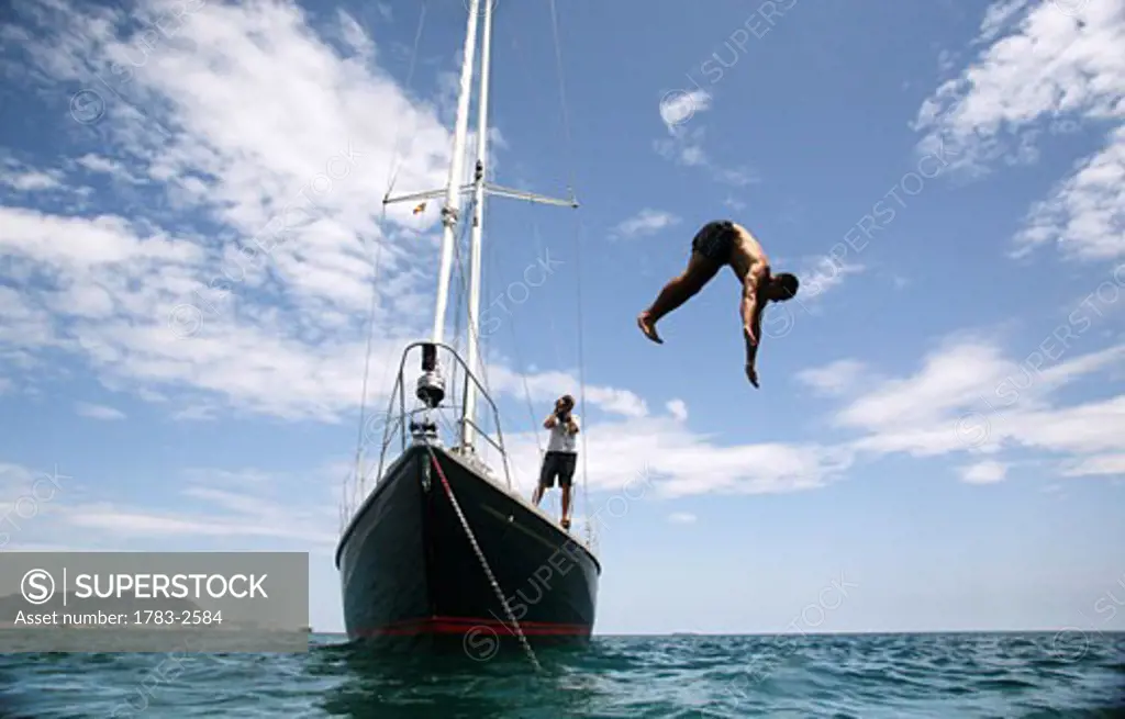 A man dives into the Sea from a yacht anchored off Gibraltar                     