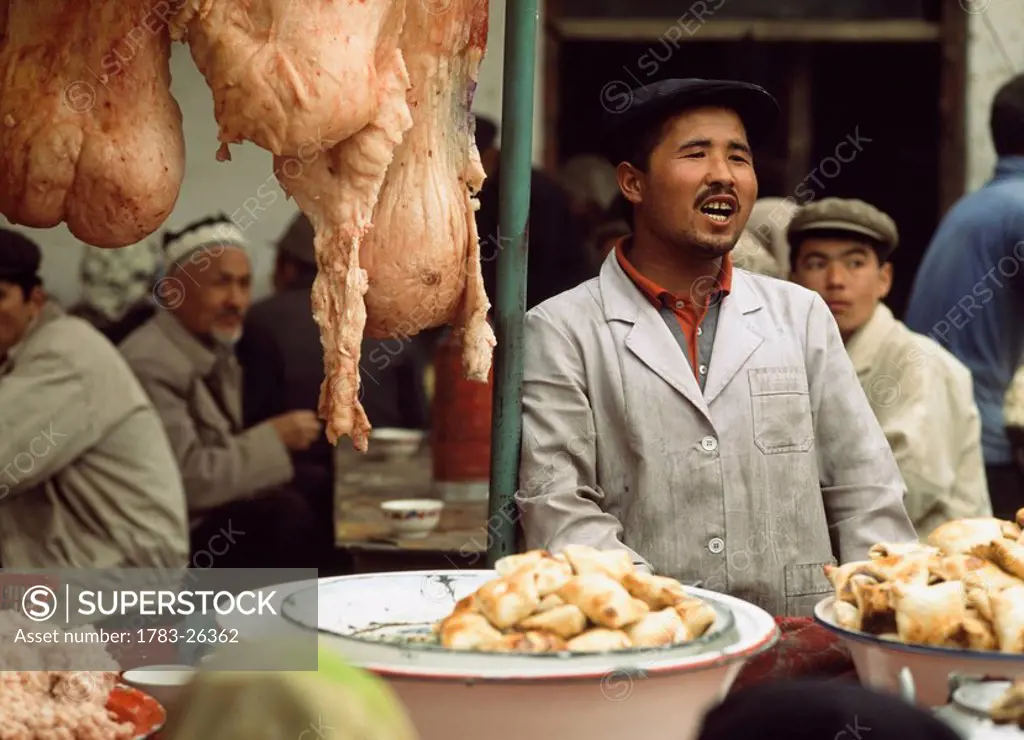 Market vendor behind stall, China