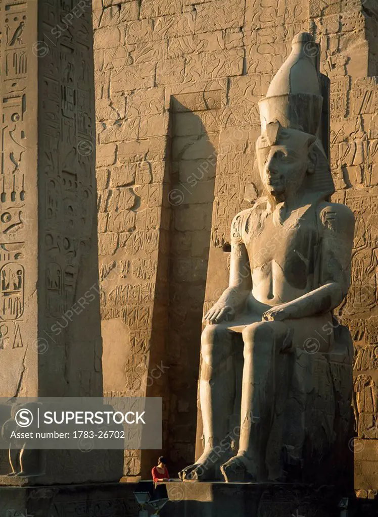 Tourist reading guidebook at obelisk, Luxor Temple, Luxor, Egypt