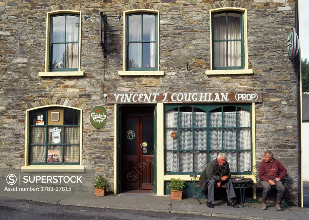 Two men sitting outside a pub, County Cork, Ireland 