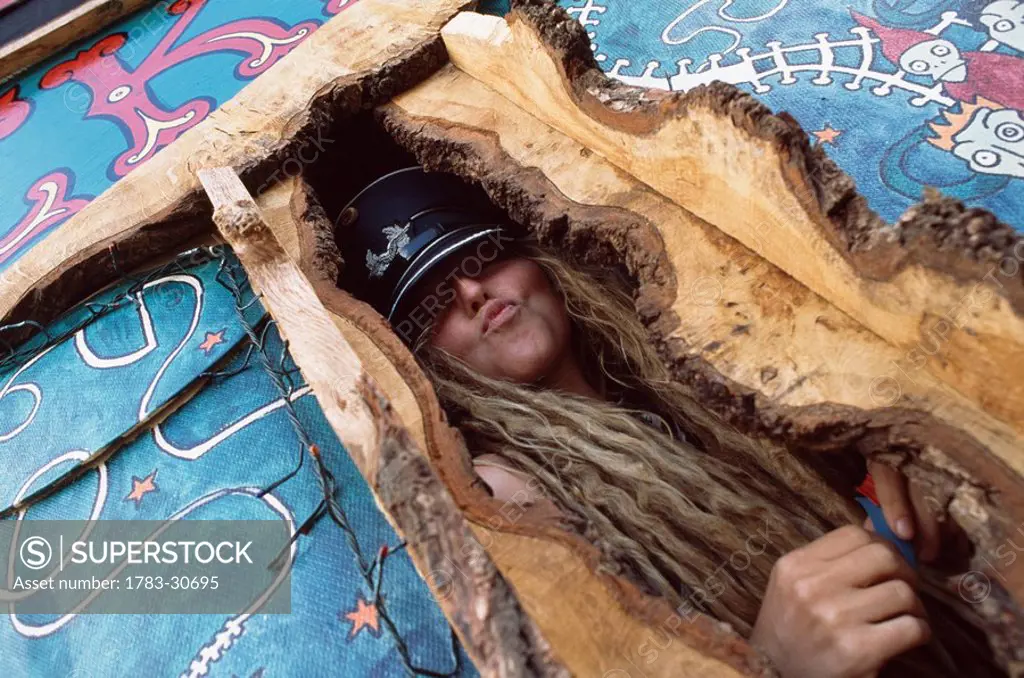 Woman posing in wooden structure, dreadlocks, hate, Glastonbury festival, Glastonbury, Somerset, England, UK