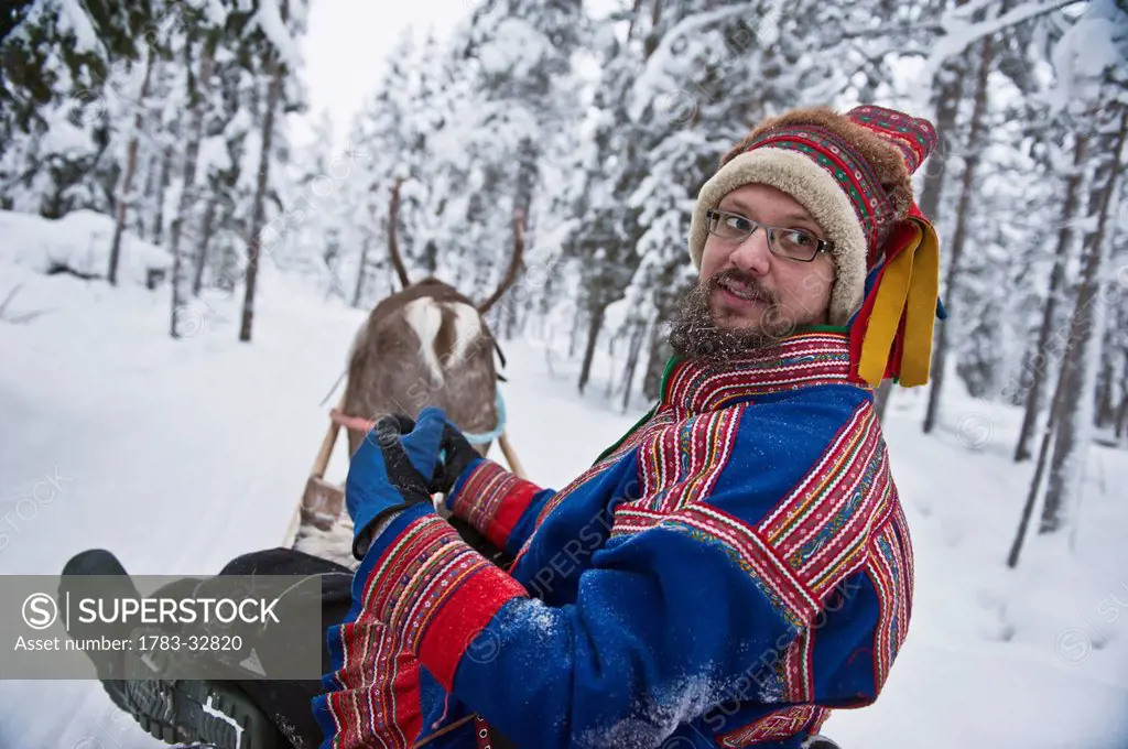 A Herder With Reindeer Wearing The Traditional Sami Clothing At Ounaskievari Reindeer Farm, Levi, Lapland, Finland