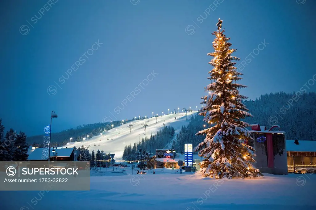 A Large Decorated Christmas Tree With Lights In Front Of The Floodlit And Ski Slopes, Levi, Lapland, Finland
