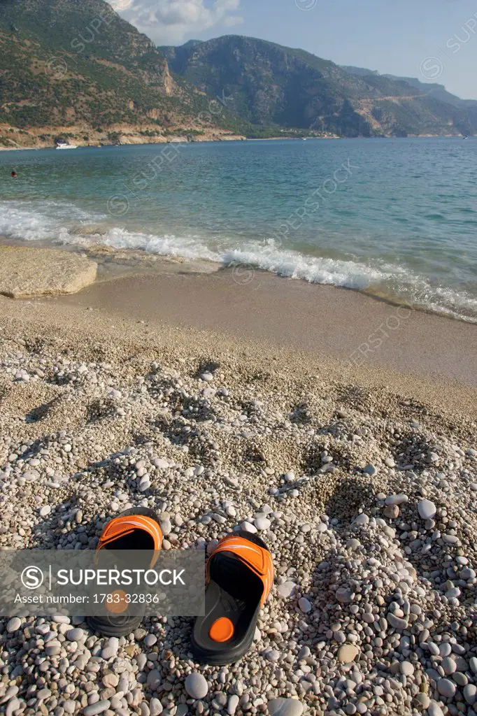 Abandoned Flip Flops On A Pebbly Beach, The National Park, Oludeniz At The Turquoise Coast, Southern Turkey