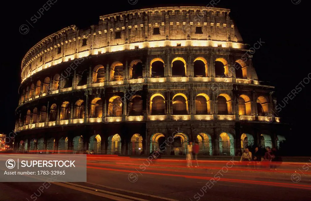 The Colosseum Lit Up At Night With Light Trails Infront