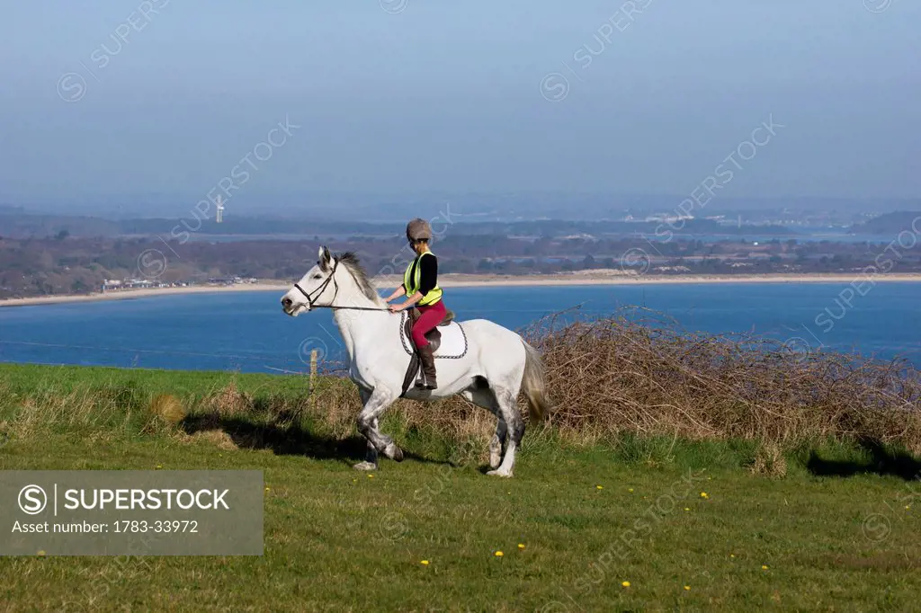United Kingdom, England, Dorset, Woman Riding Horse; Studland