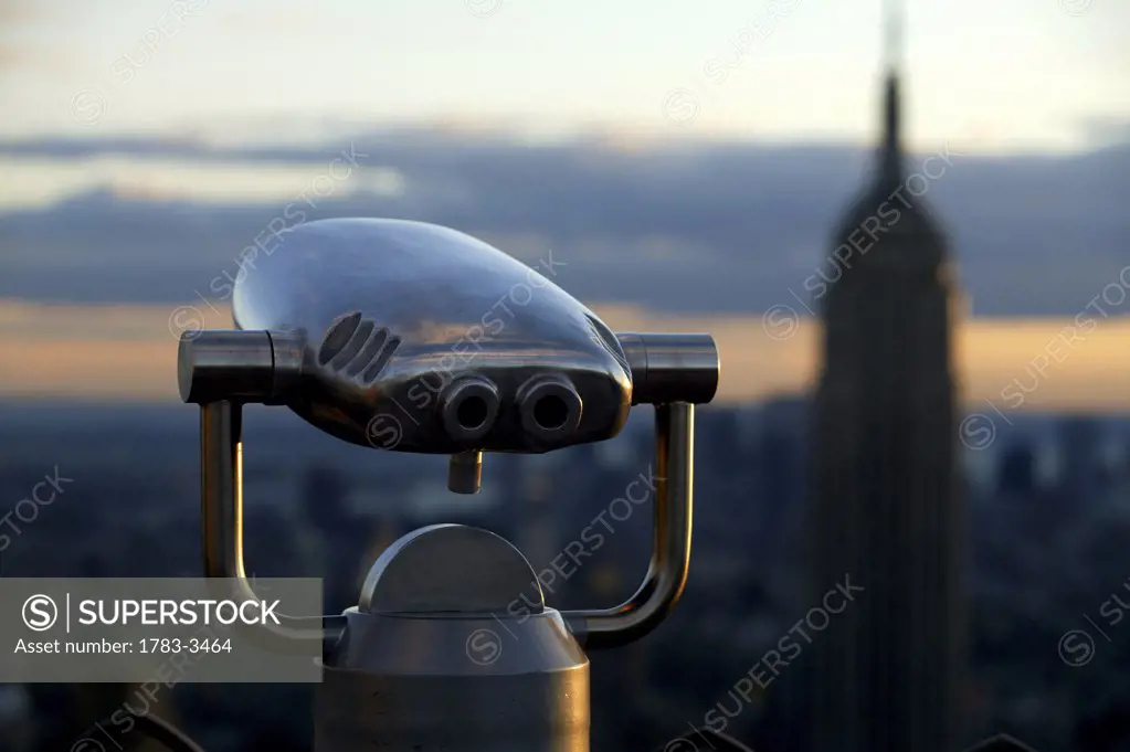 New York, USA. Art Deco binoculars and the Empire State building seen from the recently re-opened roof terraces of the Rockefeller Center.