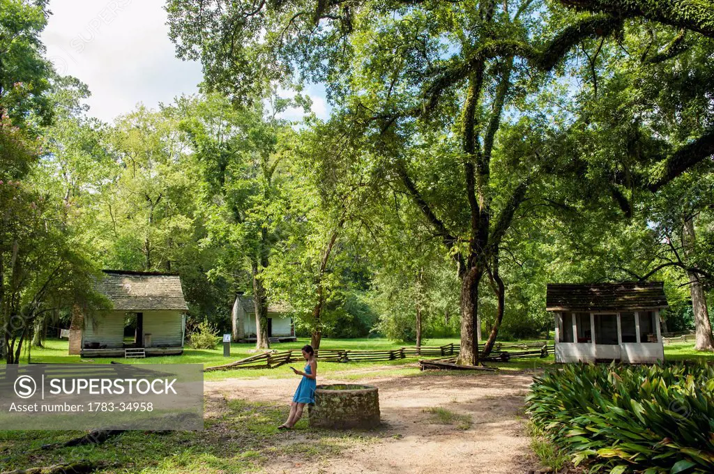 Usa, Audubon State Historic Site; Louisiana, Girl Standing By Well Near Slave Cabins In Oakley Plantation